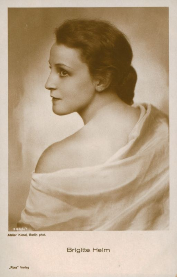 Schwarz-weiß-Porträt der deutschen Schauspielerin Brigitte Helm in einem weißen Kleid mit Text unten.