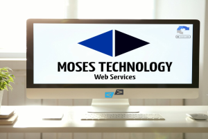 Desktop-Computer auf einem Schreibtisch in der Nähe eines Fensters mit Monitor, der "Moses Technology Web Services" anzeigt, Tastatur, Maus, Mobiltelefon, Bücher und eine Topfpflanze.