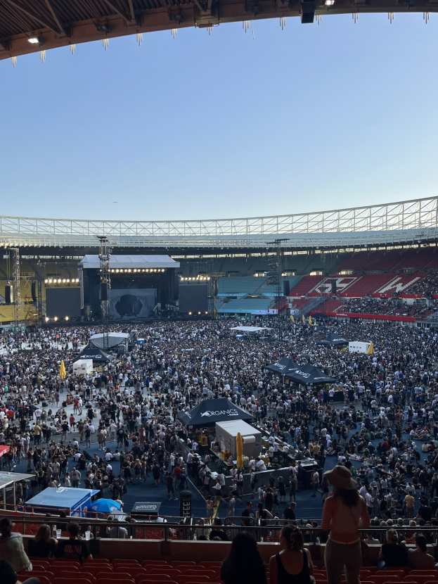 Große Menschenmenge auf Tribünen und im Stehen in einem Stadion mit Zelten, Geländern und Überdachung, unter einem überdachten Bereich in der O2 Arena in London.