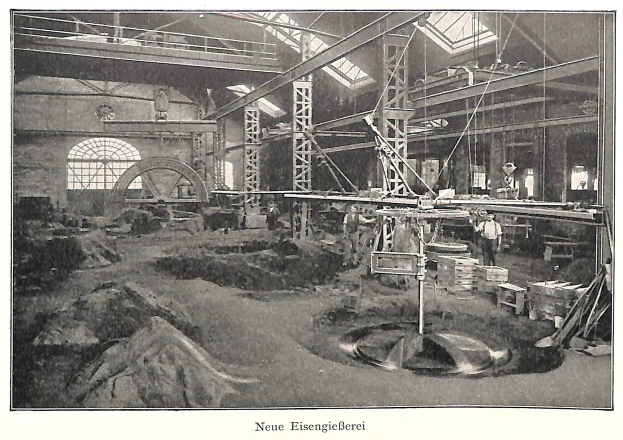 Schwarze und weiße Fotografie einer Fabrik mit Arbeitern, die Maschinen bedienen, Metallstangen und Pfähle, beschriftet mit "Neue Eisengießerei, die erste Fabrik in Deutschland."