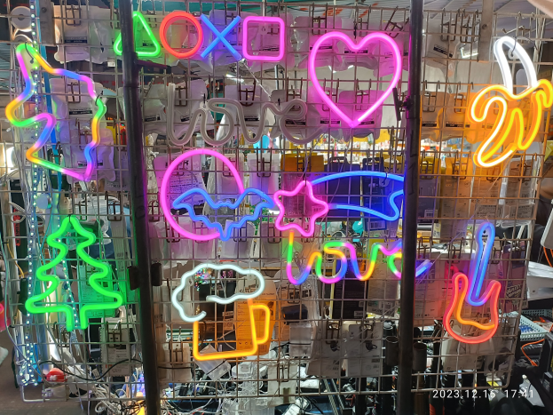 Ein Geschäft mit zahlreichen bunten Neon-Schildern, die von der Decke hängen und ein farbenfrohes Display schaffen.