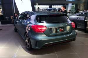 Ein Mercedes-Benz A-Klasse Hatchback auf der IAA in Frankfurt, ein schlankes, modernes Design mit glänzendem Schwarz und Chromakzenten, umgeben von einer Gruppe von Menschen.