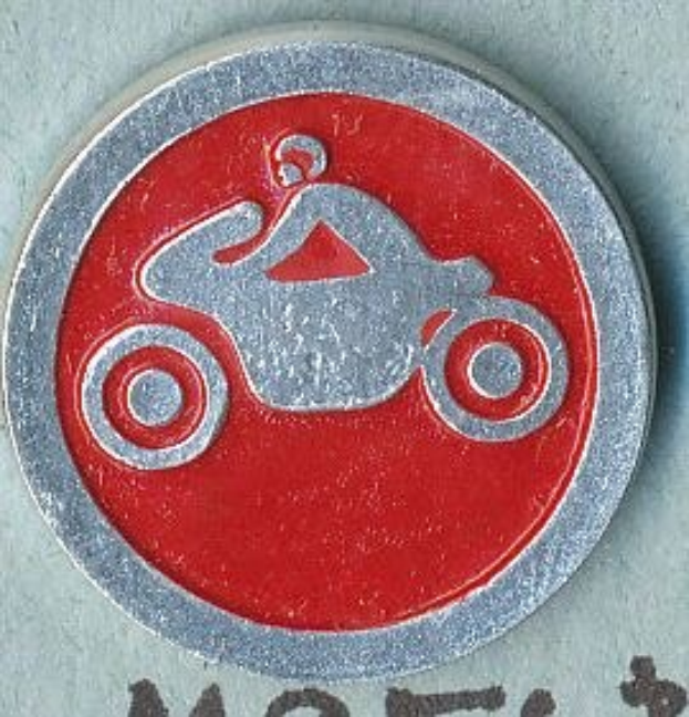 Rotes und silbern rundes Schild mit einer Person in einem Helm auf einem Motorrad, mit Text, der den Namen des Motorrads angibt.