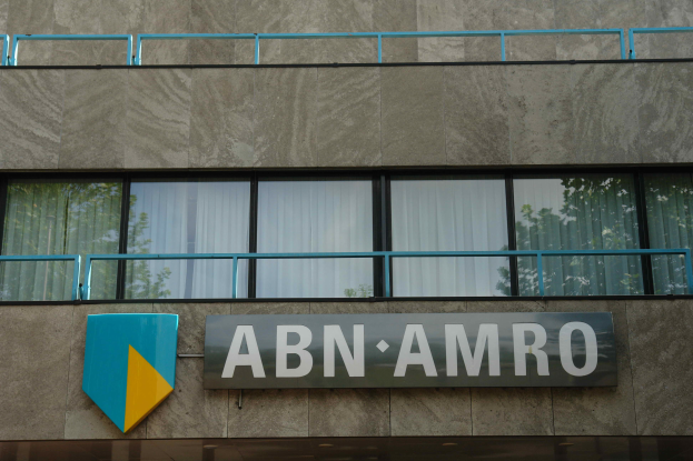 Ein Gebäude mit "ABN AMRO"-Schriftzug, ein Schild, das darauf hinweist, dass es der Hauptsitz ist, Geländer und Glasfenster mit Vorhängen, in Verbindung mit einer Strafe von 1,5 Milliarden US-Dollar.
