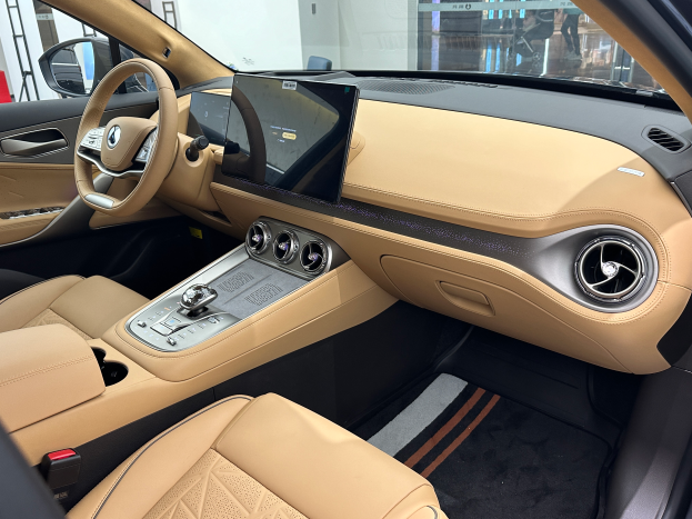 Das Innere eines Mercedes-Benz S-Klasse Limousinen auf der Frankfurter Motor Show, mit einem Lenkrad, Armaturenbrett, Bildschirmen, Knöpfen, Sitzen, Seitenspiegeln und Glasfenstern, durch die Menschen, Gebäude und andere Gegenstände im Hintergrund zu sehen sind.