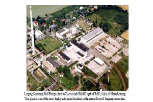 Eine Luftaufnahme eines Industriegebiets in Leipzig, Deutschland, mit Gebäuden, Bäumen, Pflanzen, Gras, Straßen, Masten und anderen Objekten und dem Text "Leipzig Germany - Bell Europe" unten.