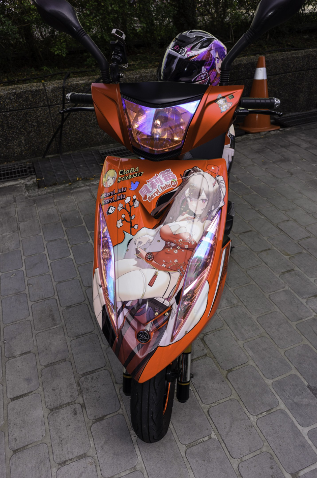 Ein oranges E-Scooter auf einer Straße geparkt mit einem Helm daneben, neben einem Verkehrskegel, einer Wand und Bäumen im Hintergrund.