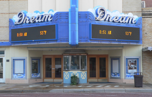 Außenansicht des Dream Theaters in St. Louis, Missouri, mit Glasfenstern und -türen, einem Namensschild, einem Mülleimer, einem Topfpflanzen und einer Straße im Vordergrund.