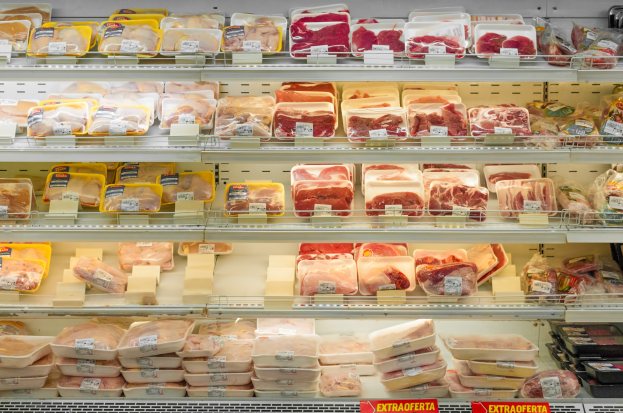 Ein gut organisierter Supermarktboden mit verschiedenen Arten von ordentlich sortiertem Fleisch mit sichtbaren Preisschildern.