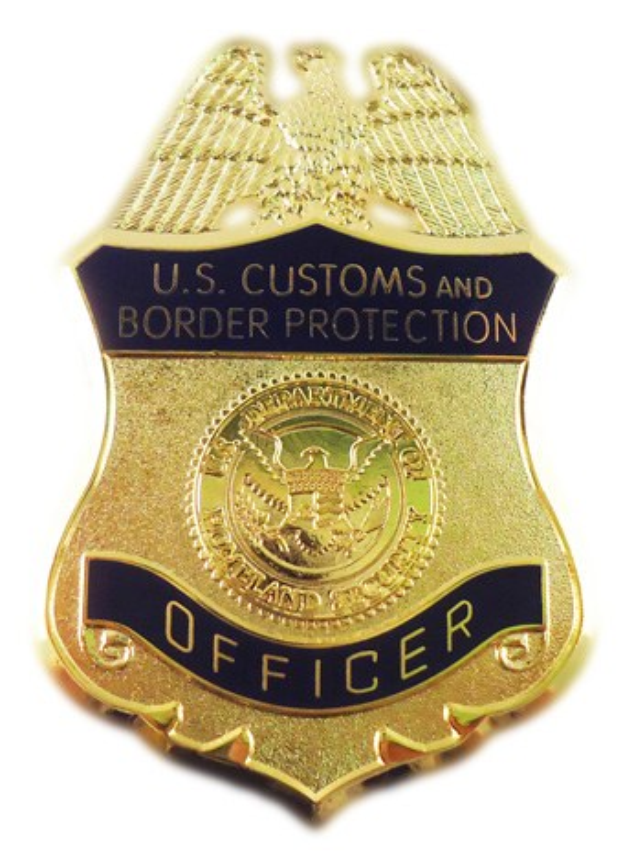 Goldes Abzeichen mit der Gravur "U.S. Customs and Border Protection Officer" in der Mitte auf einem weißen Hintergrund.