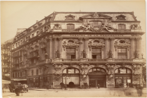 Altes Foto des Théâtre de la Renaissance in Paris mit seiner prächtigen Fassade, die mit Fenstern, Säulen, Bögen und Skulpturen geschmückt ist, mit einigen Menschen und Fahrzeugen im Vordergrund und dem Himmel im Hintergrund.
